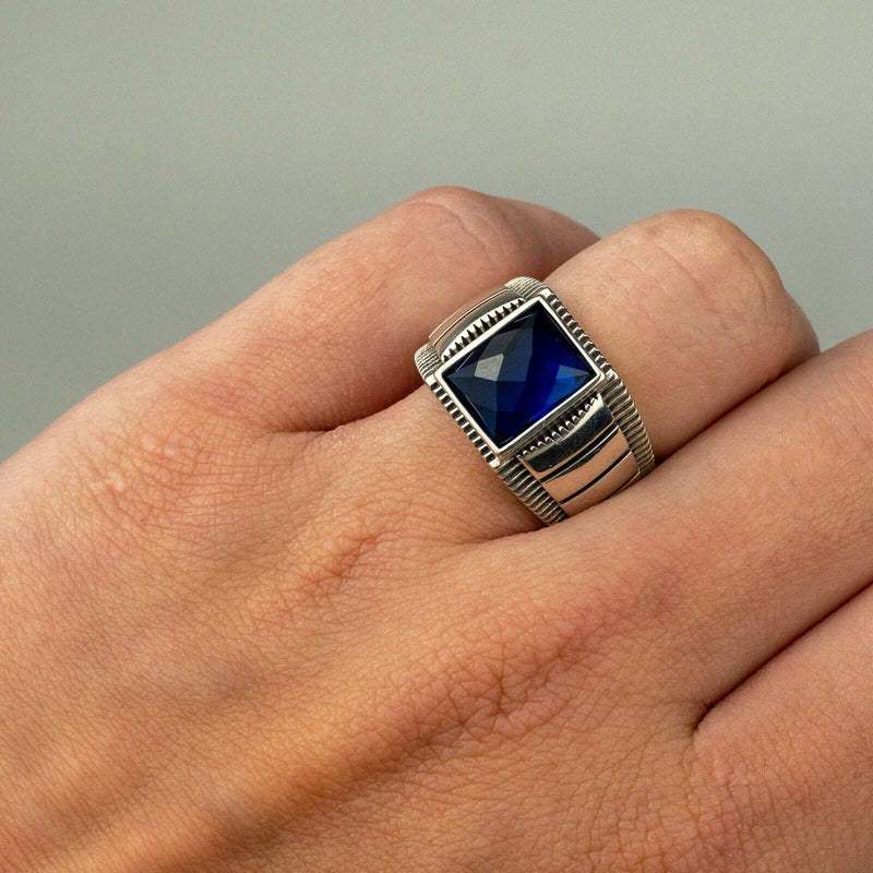 Men's sterling silver ring with blue cubic zirconia crystal.