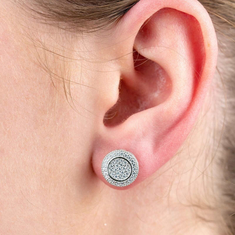 Round silver earrings with simulated diamond pave setting on ear.
