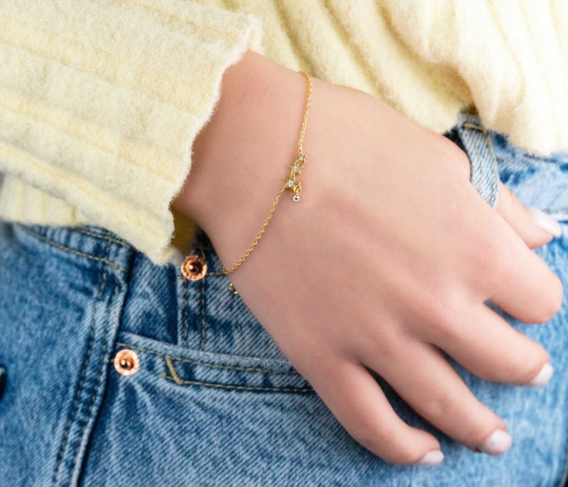 Delicate stars bracelet in 925 sterling silver with 14K gold plating on wrist.