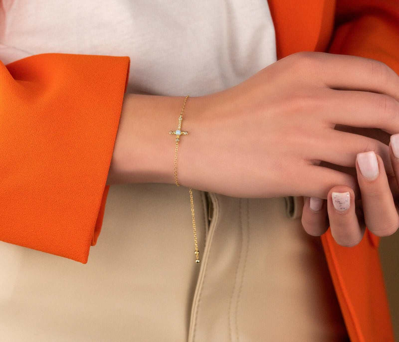 Sterling silver cross bracelet with 18K gold plating on woman's wrist.