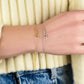 Stars bracelet in 925 sterling silver and 14K gold plated, featuring tiny star charms, worn on a wrist.