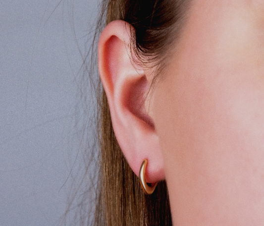 925 Sterling Silver Huggie Hoop Earring on woman's ear, small gold-plated jewelry.