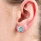 Round silver earrings with simulated diamond pave setting on ear.