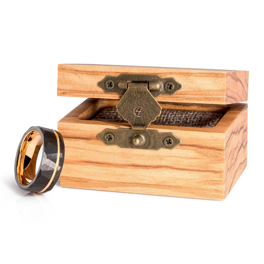 Black tungsten ring with comfort-fit design, displayed next to a wooden box.