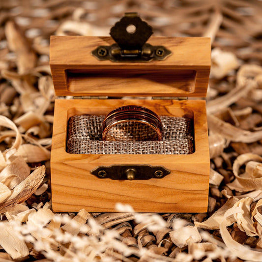 Guitar String Whiskey Barrel Ring in olive wood box showcasing rose gold and tungsten craftsmanship.