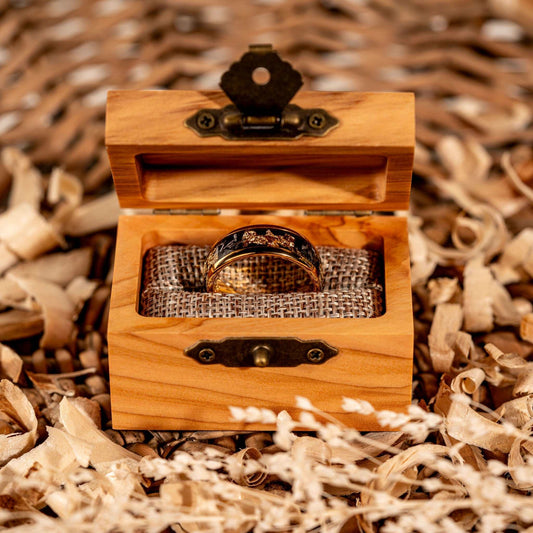 Meteorite Gold Leaf Ring in wooden box on rustic background.